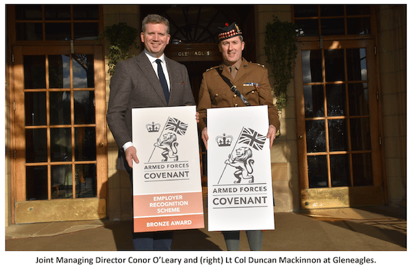 Conor O'Leary and Duncan Mackinnon holding the Armed Forces Covenant logos