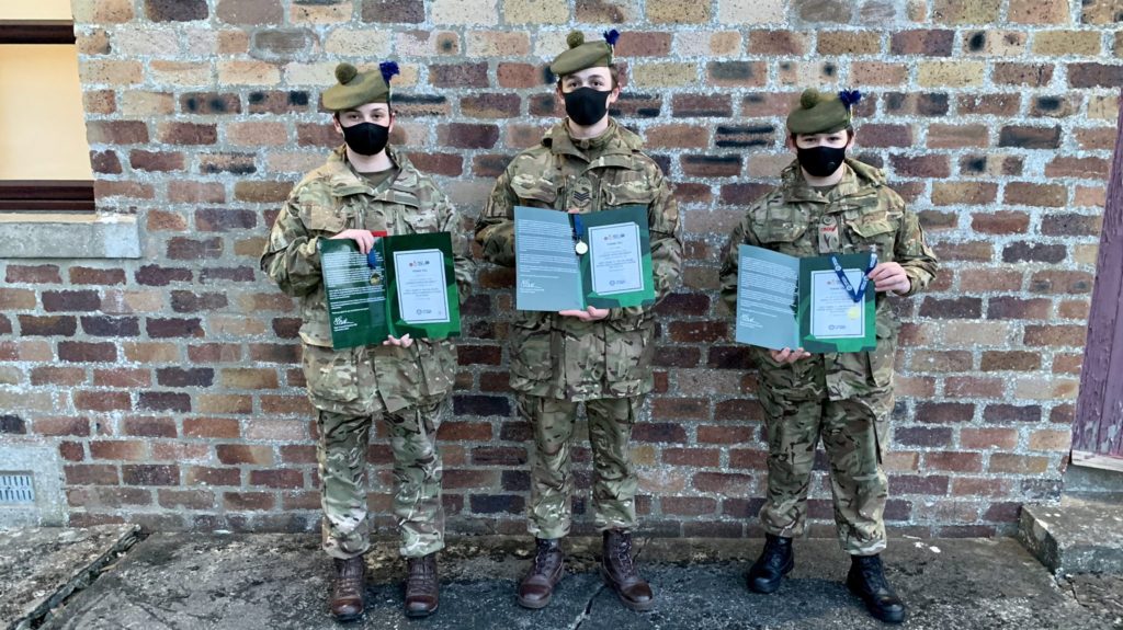 Three cadets with certificates.