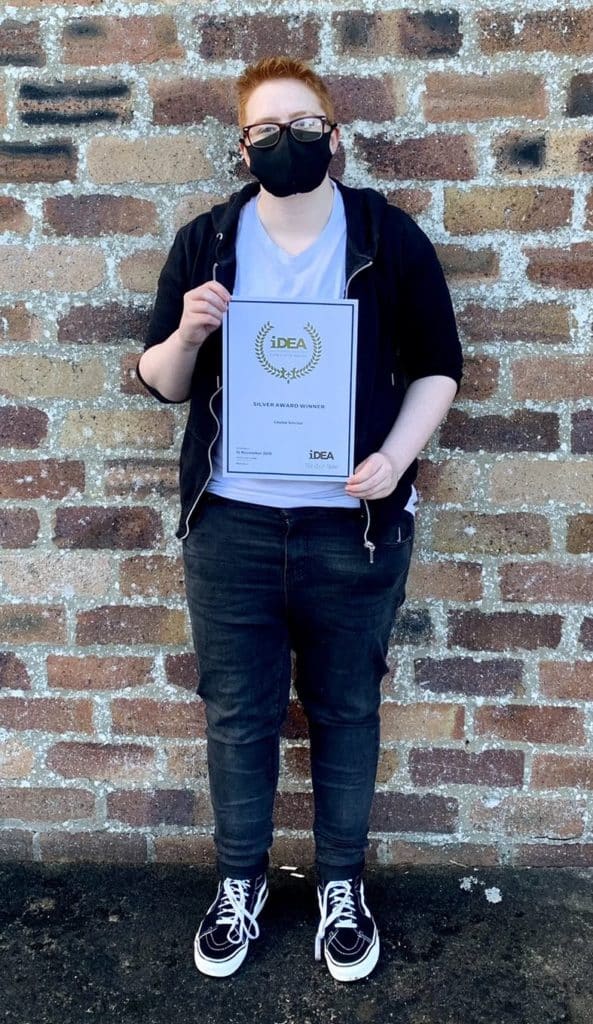 Former cadet holds award certificate.