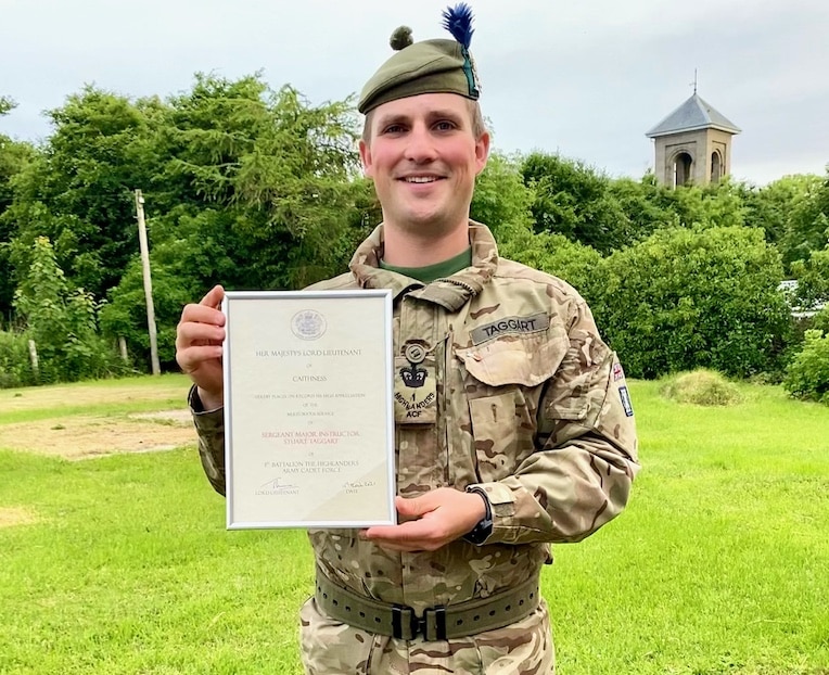 Cadet instructor holding certificate.