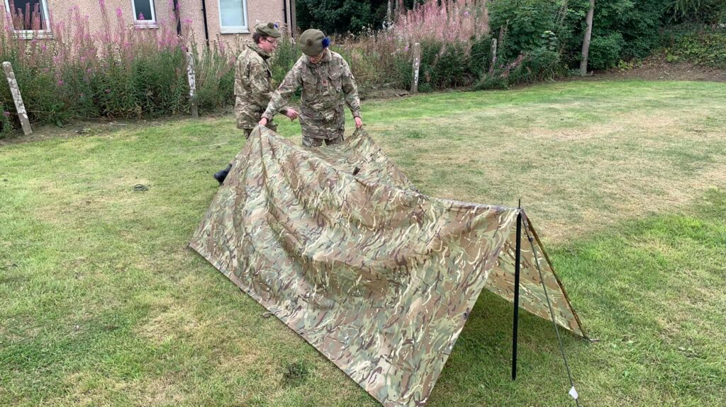 Two cadets build a shelter.