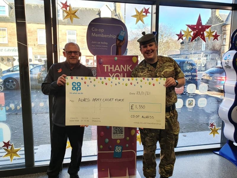 Lt Stuart Nicolson accepting a cheque for £1350 from the Alness Co-op for Alness Detachment.