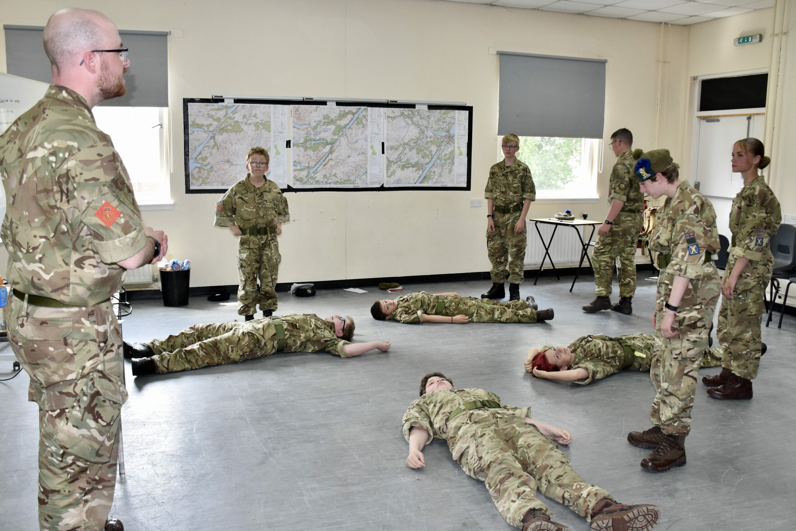 Nine cadets practicing CPR with Adult Volunteer demonstrating