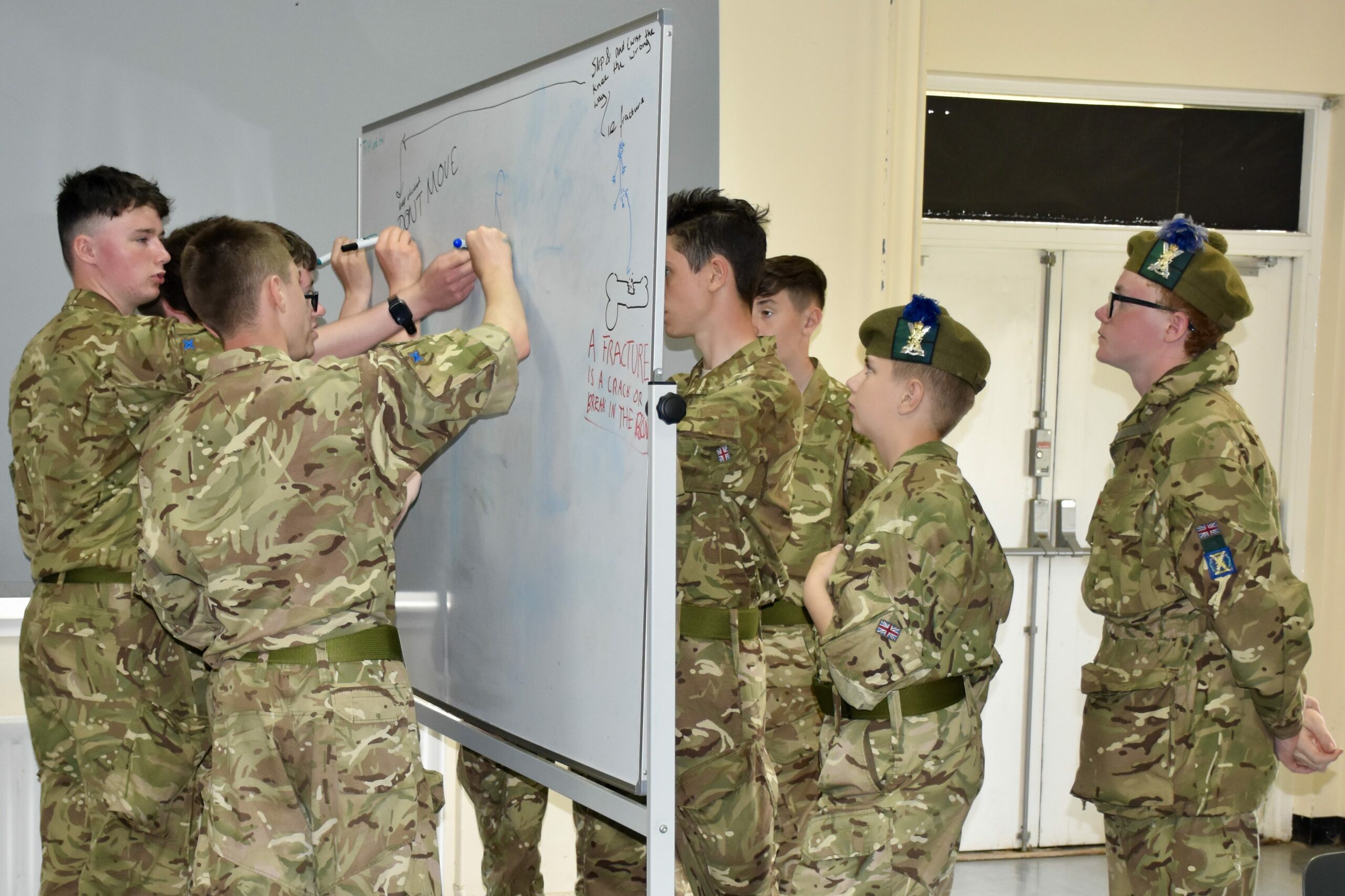 Eight cadets writing on whiteboard