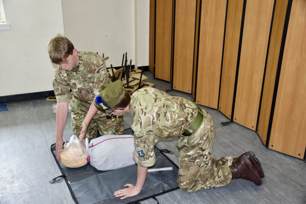 Two cadets practicing CPR on dummy