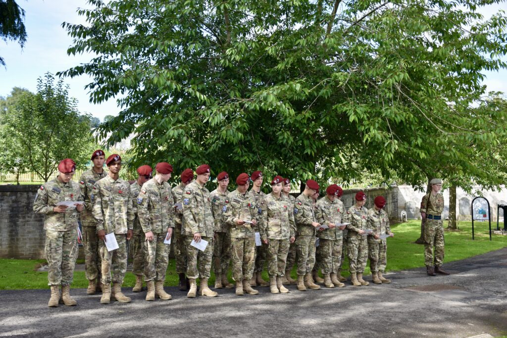 Group of cadets holding and reading programmes