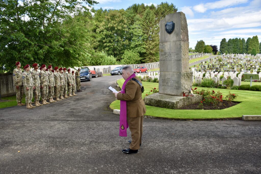 Group of cadets and Chaplain in front of memorial