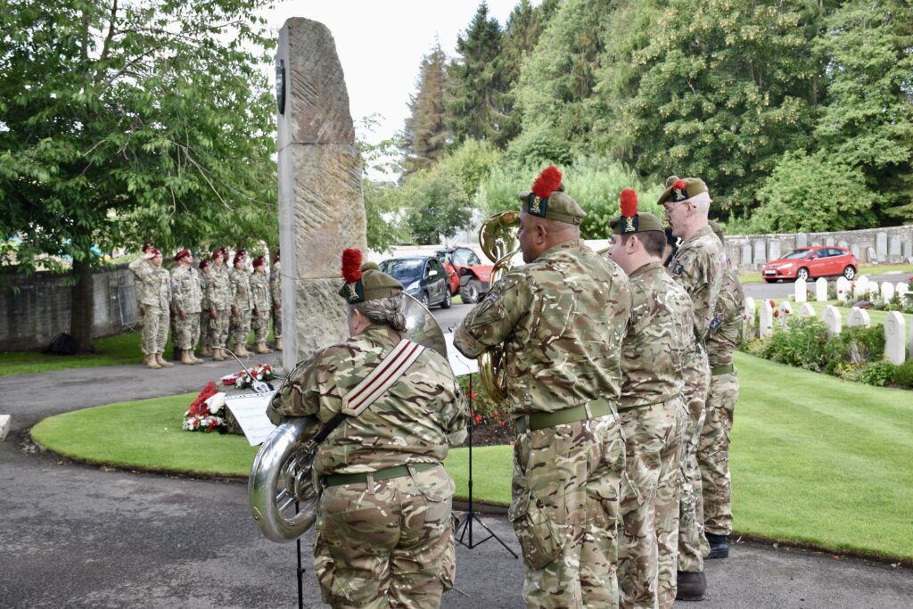 Six musicians with group of cadets in the background