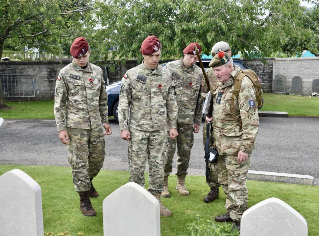 Adult Volunteer and four cadets looking at war graves