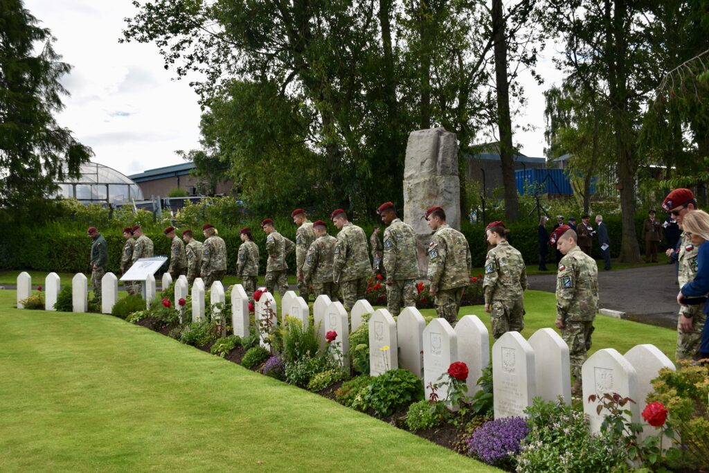 Polish Adult Volunteer, principal and fifteen cadets looking at war graves