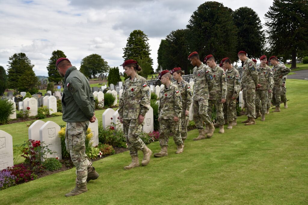 Polish Adult Volunteer and thirteen cadets looking at war graves