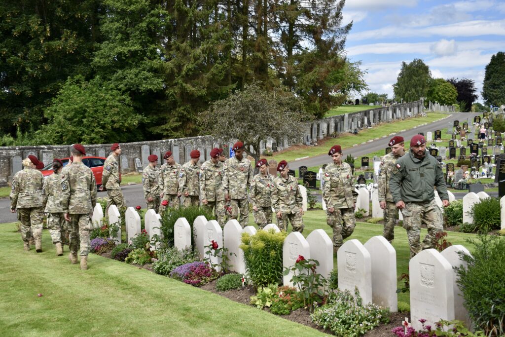 Polish Adult Volunteer and sixteen cadets looking at war graves