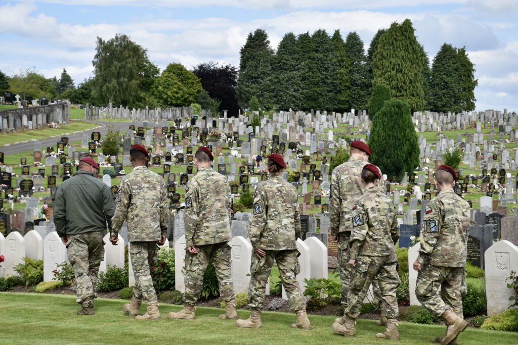 Polish Adult Volunteer and six cadets looking at war graves