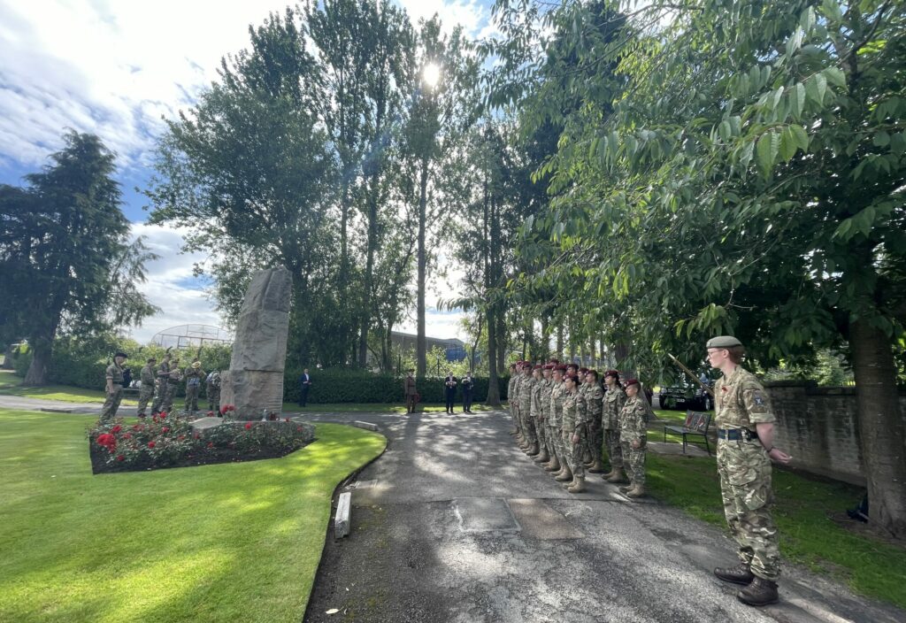 Cadets, musicians and local dignitaries standing by memorial