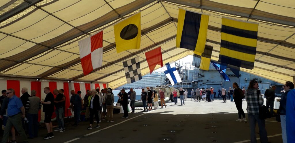 Guests on the ship's deck with flags hanging from the ceiling
