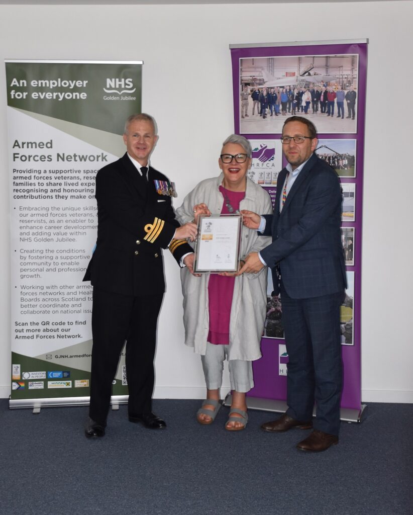 Commander Gary Farmer presents the NHS Golden Jubilee Gold Award revalidation.