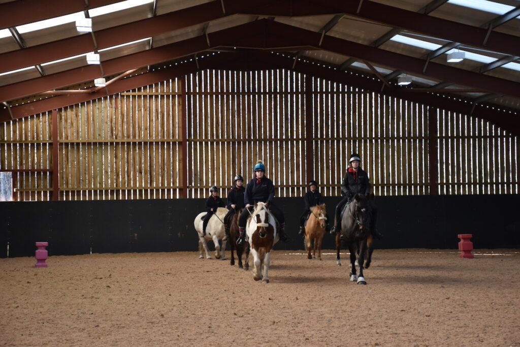 Six people riding horses in two rows