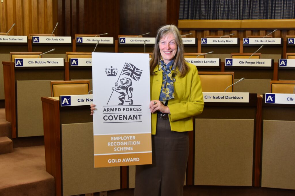 Aberdeenshire Council HR Manager Glenda Gray displays the Defence Employer Recognition Scheme logo.