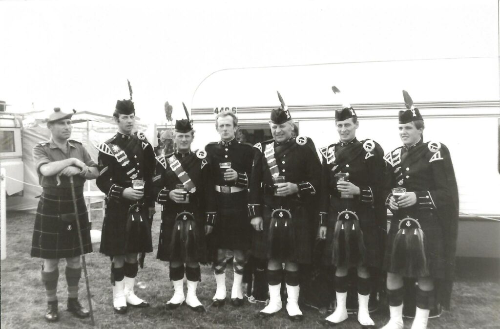 Six pipers pose with Roddy Balfour (left).