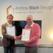 Two men holding the Armed Forces Covenant and Defence Employer Recognition Scheme certificates.