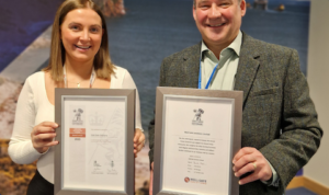 Samantha Johnston and Ray Watt showing off Well-Safe Solution's Armed Forces Covenant and ERS Bronze Award certificates.