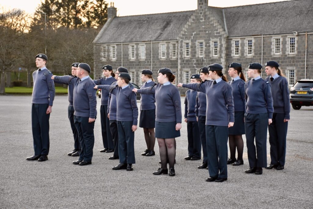 Cadets with arms outstretched in a group.