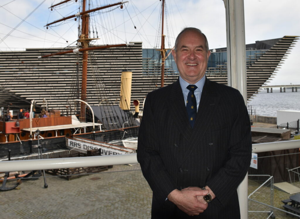 The new Chair smiling with the Royal Research Ship Discovery and V&A Dundee in the backdrop