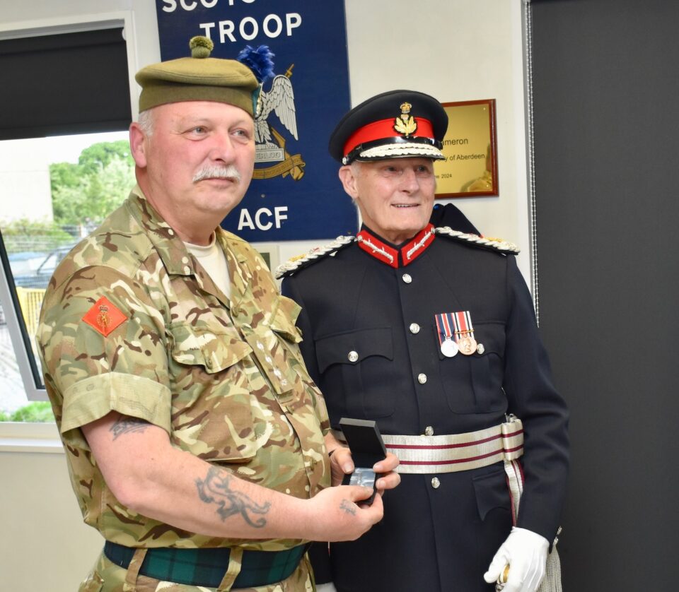 Captain Mathers displays the clasp for his Cadet Force Medal.
