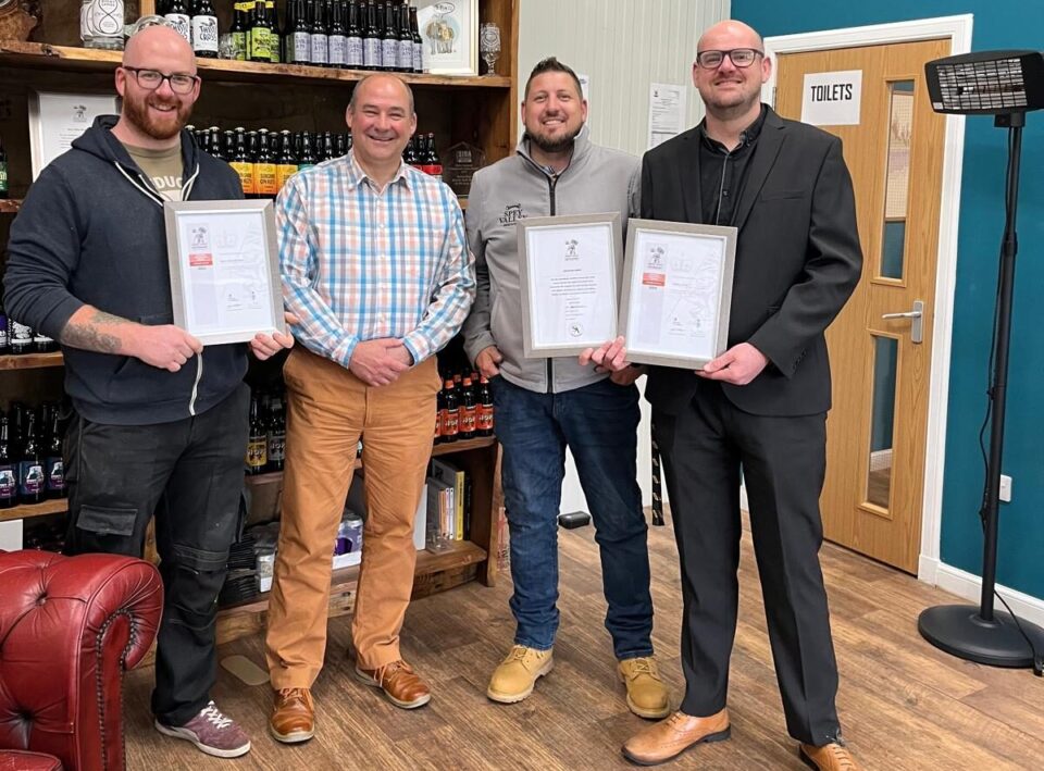 Four men holding there certificates.
