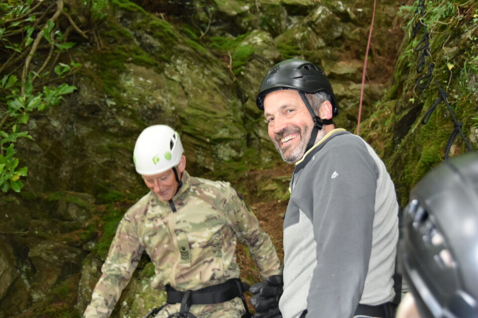 Two men at the foot of a rocky area in Dunkeld.