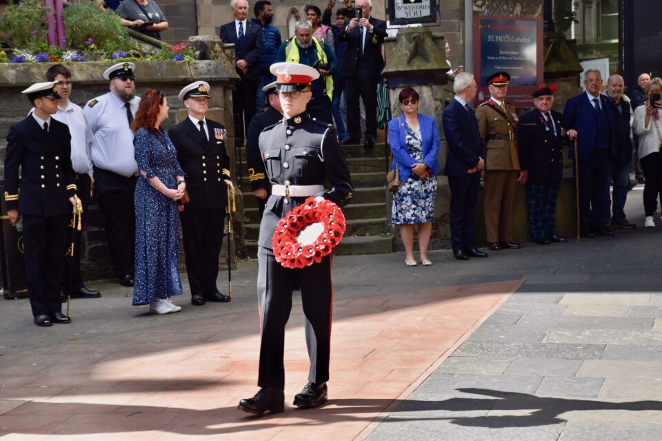 A cadet from the Royal Marines carries a wreath to be laid at the statue of Admiral Duncan.