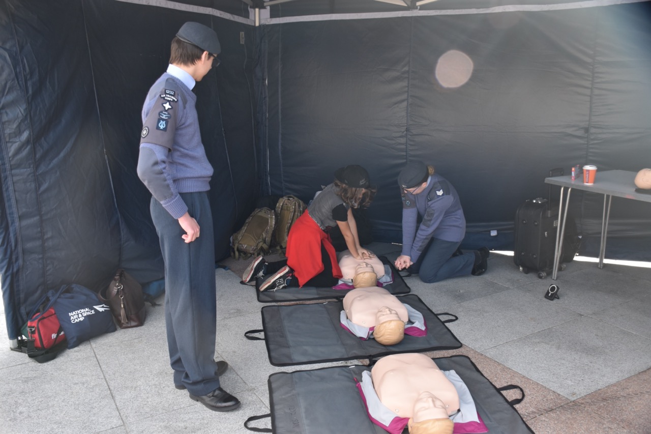 A cadet teaching a child how to do CPR.