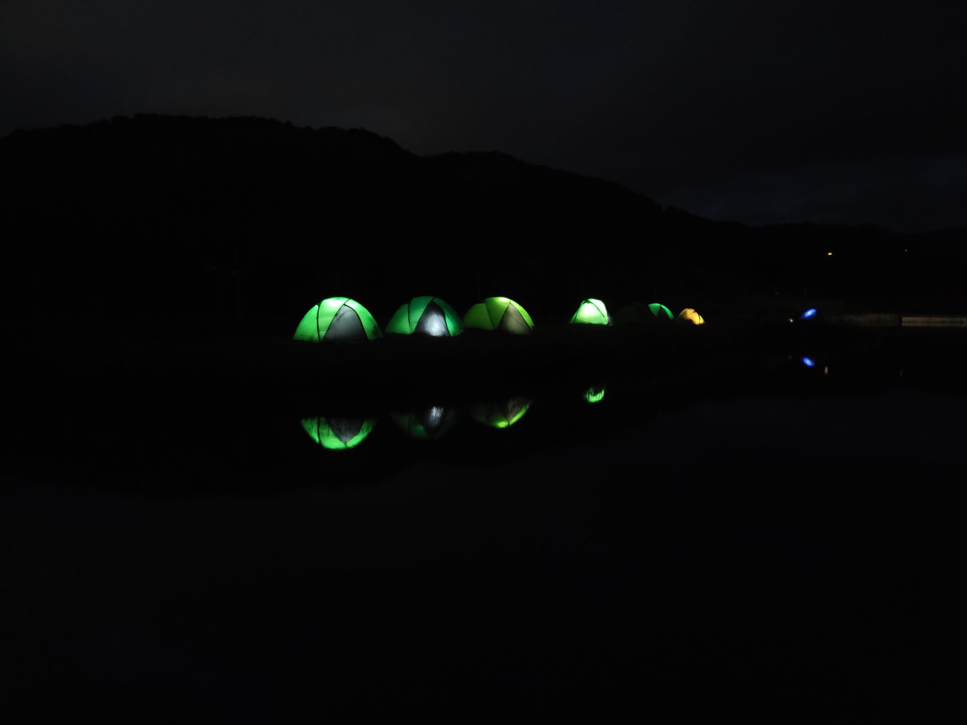 Tents illuminated in the darkness at Loch Tay.