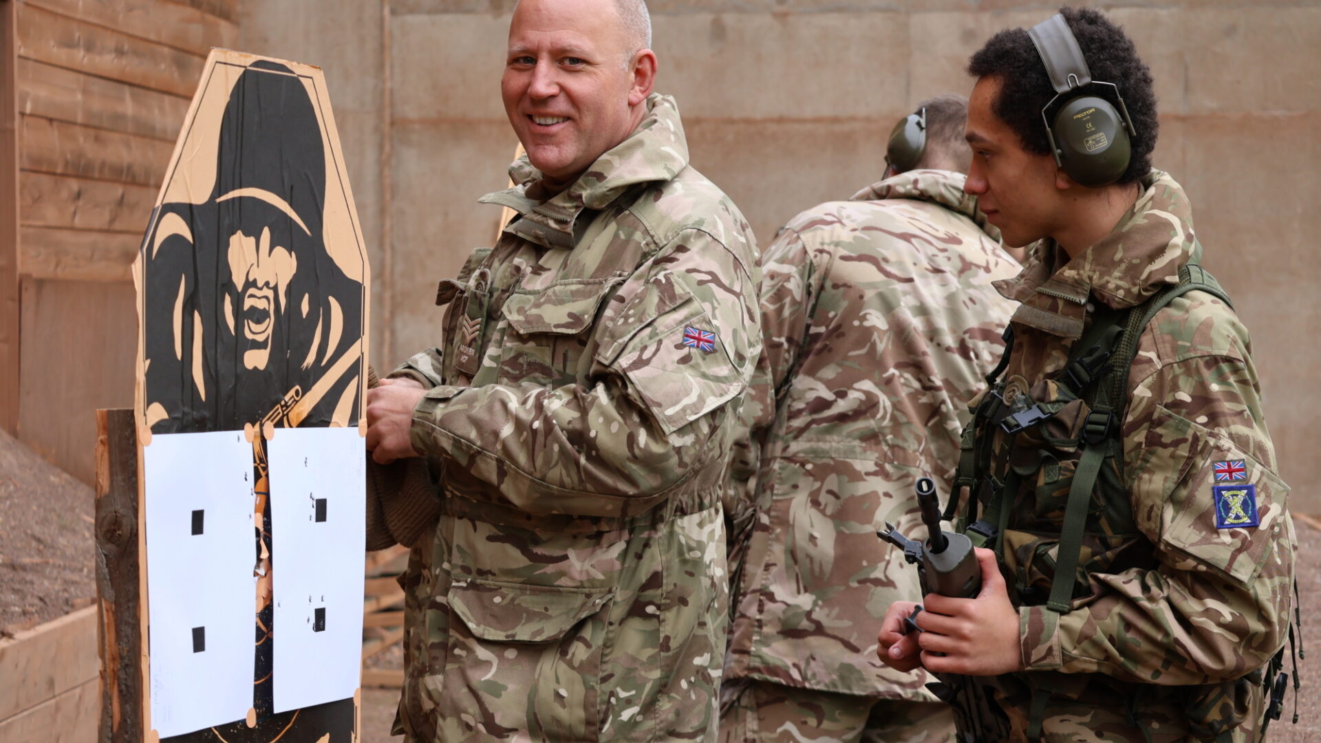 An Adult Volunteer and cadet look at one of the targets.