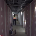 A contractor stands in a first floor corridor.