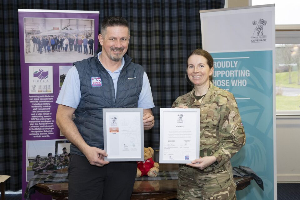 Tony Brown, CEO of Outfit Moray, and Group Captain Sarah Brewin holding the Armed Forces Covenant and ERS Bronze Award certificates at RAF Lossiemouth.