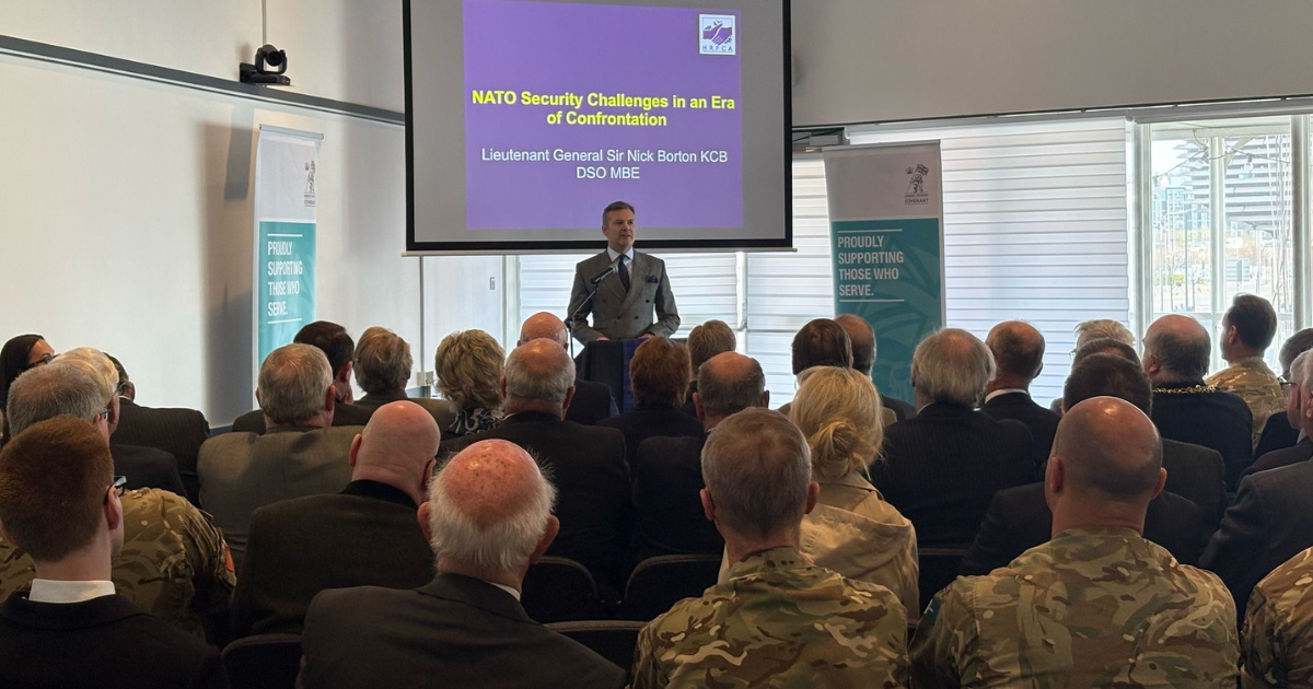 A man standing at a lectern in front of an audience.