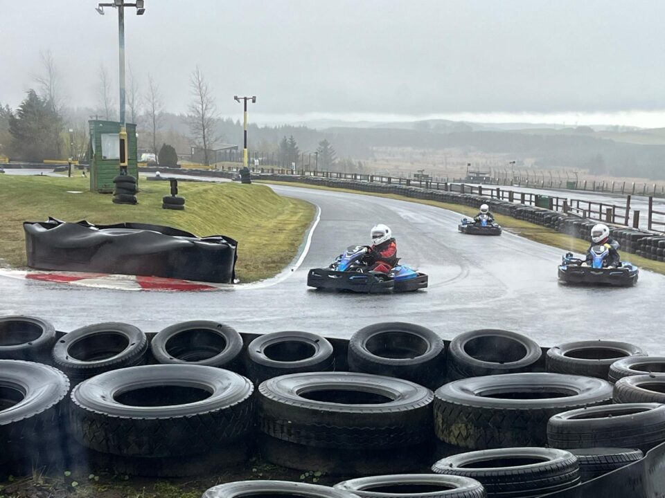 A trio of racers approach a corner at Knockhill Racing Circuit.