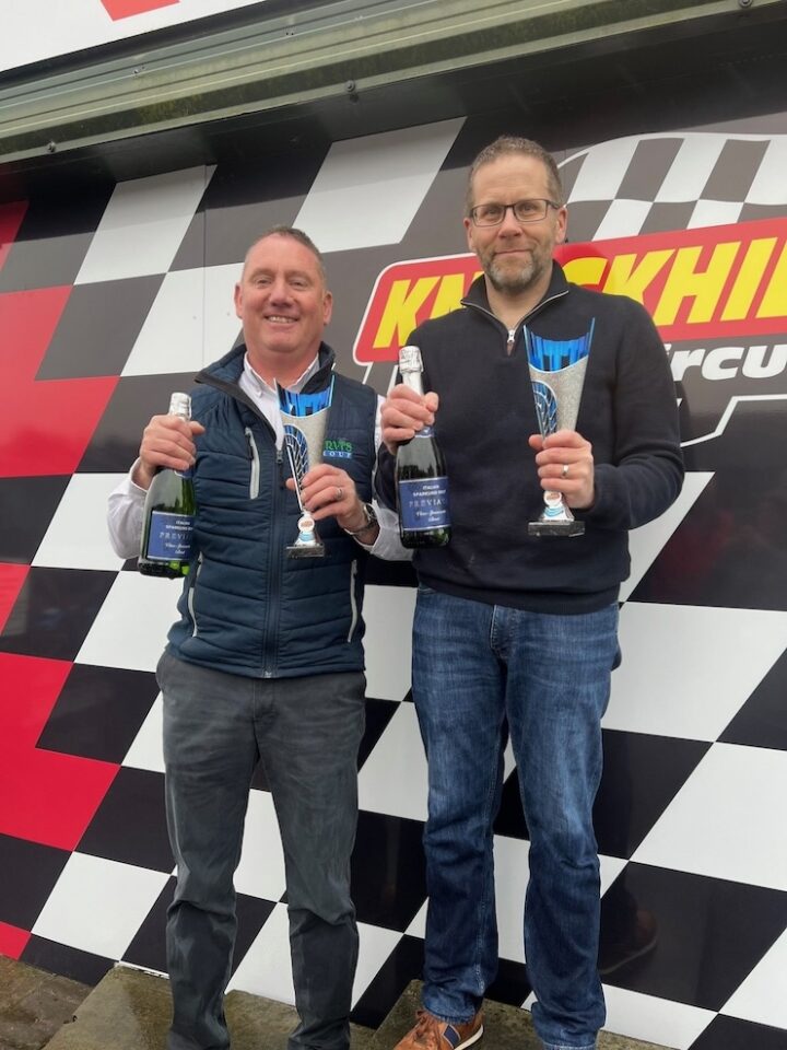 The winning two-person team from Purvis Plant Hire Ltd hold trophies and Champagne.