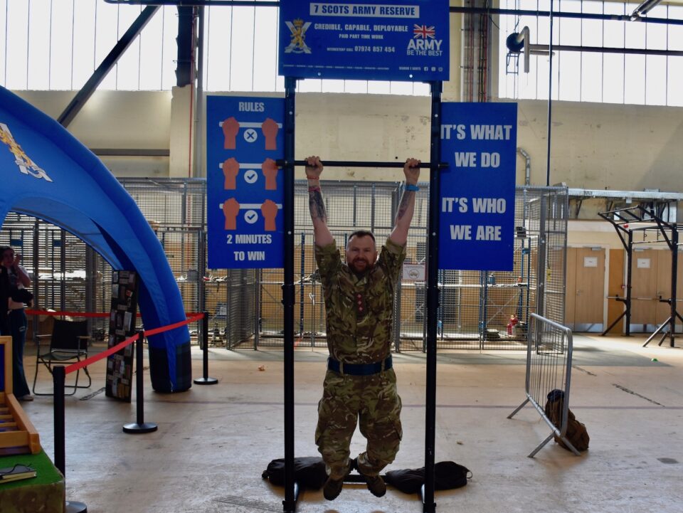 Captain Scot Shaw of 7 SCOTS hangs from a pull-up bar.