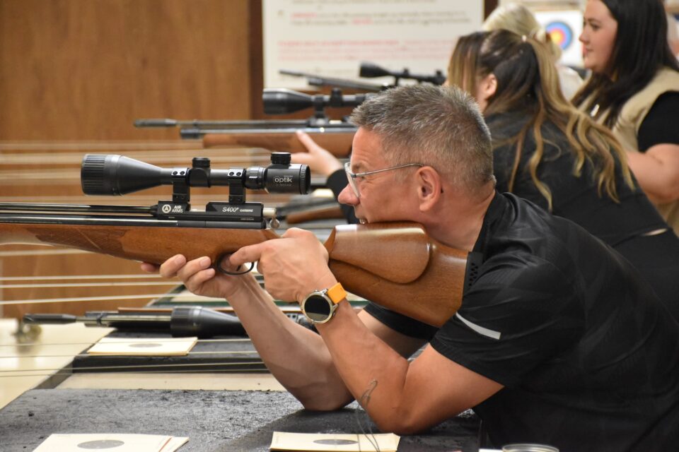 A participant takes aim with an air rifle.