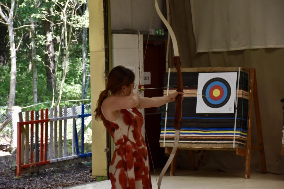 A person takes aim during the archery activity.